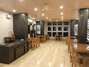a restaurant with wooden tables and chairs in a room at The Mangrove Cove "200Mtrs from Beach" in Shādipur