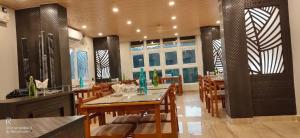 a dining room with a table and chairs and windows at The Mangrove Cove "200Mtrs from Beach" in Shādipur +4 photos