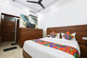 a bedroom with a large bed and a television at FabHotel Lotus Star in New Delhi