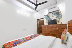 a bedroom with a bed and a wooden dresser at FabHotel Lotus Star in New Delhi