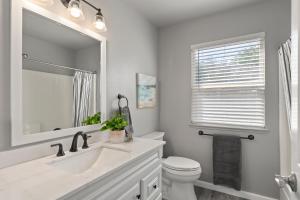 a bathroom with a sink and a toilet and a mirror at Sunset Paradise in Pontud