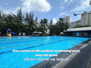 a large swimming pool with a sign referring to the outdoor swimming pool near the hotel at THE STAR HOTEL - PHU MY HUNG, HO CHI MINH - Korean Buffet Breakfast in Ho Chi Minh City