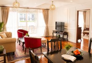a living room with a table and a couch and a television at Dhavara Boutique Hotel in Vientiane