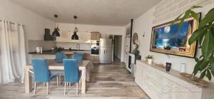 a kitchen and dining room with a table and blue chairs at Le pietre di Mario in Bari Sardo