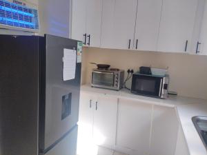 a kitchen with two microwaves and a refrigerator at Vee's Cottage in Bellville