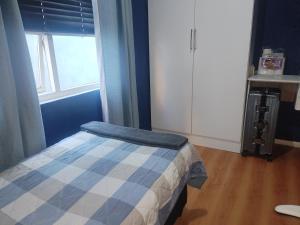a small bedroom with a bed and a window at Vee's Cottage in Bellville