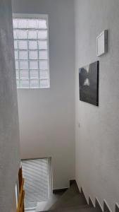 a white room with a window and a staircase at Guest House Ulnika in Vusanje