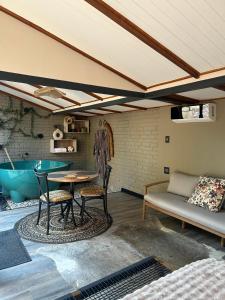 a room with a table and chairs and a tub at Nest-Dove's Nest in Howick
