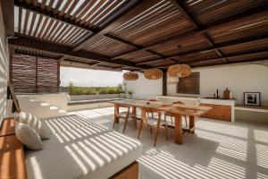 a dining room with a wooden table and chairs at Suasana by AYA in Uluwatu