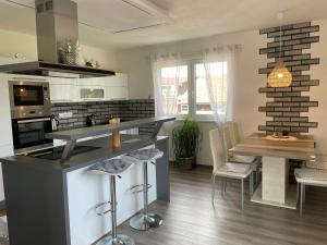 a kitchen with a counter and a table and chairs at Apartmán u Fryšávky in Fryšava