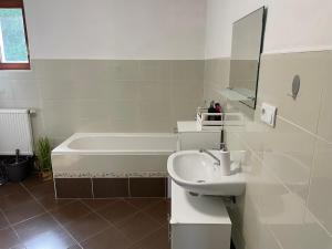 a white bathroom with a sink and a bath tub at Apartmán u Fryšávky in Fryšava +35 photos