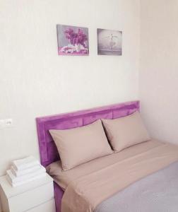 a bed with a purple headboard in a room at Cozy Family Apartment in Tbilisi City