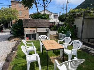 a group of white chairs and a table and a grill at ハートリサイデェンス 河津 in Kawazu
