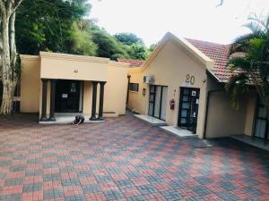 a dog laying on a brick driveway in front of a building at Nala Guesthouse in Ellisras