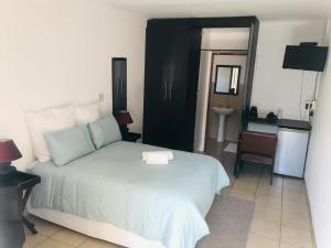 a bedroom with a large bed and a bathroom at Nala Guesthouse in Ellisras