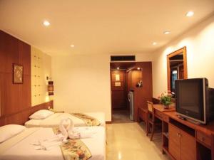 a hotel room with two beds and a television at Royal Twins Palace Hotel in Pattaya