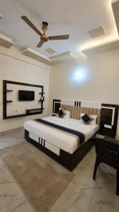 a bedroom with a large bed and a ceiling fan at The Grand Girivar Vrindavan # Lavis & Luxury Rooms # in Vrindāvan