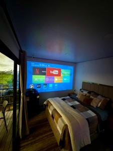 a bedroom with a large screen on the wall at Tres Raices Cabañas in Gómez Plata