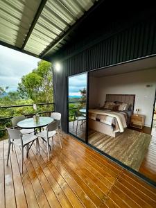a bedroom with a bed and a table on a deck at Tres Raices Cabañas in Gómez Plata