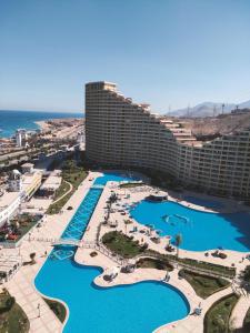 an aerial view of a hotel with pools and the ocean at بورتو السخنه الاهرامات in Ain Sokhna
