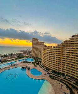 an aerial view of a resort with a pool and the ocean at بورتو السخنه الاهرامات in Ain Sokhna