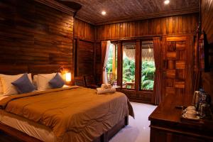 a bedroom with a bed in a room with wooden walls at Pemedal Beach Resort in Nusa Lembongan +170 photos