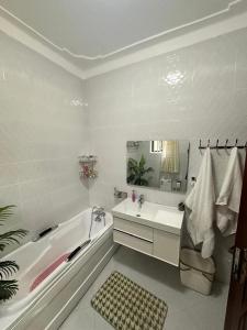 a white bathroom with a tub and a sink at Ashland Gardens in Vumba +6 photos