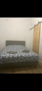 a bedroom with a bed with a blue comforter at Dodo express in Saint-Brieuc