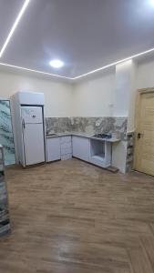 an empty room with a kitchen and a refrigerator at Villa zahra 7 in Kêf Bisnês