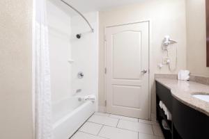 une salle de bain blanche avec douche et lavabo dans l'établissement Comfort Suites Morrow- Atlanta South, à Morrow