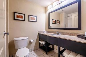 une salle de bains avec toilettes et un grand miroir dans l'établissement Comfort Suites Morrow- Atlanta South, à Morrow 17 autres photos