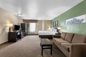 a hotel room with a bed and a couch at Sleep Inn Nampa near Idaho Center in Nampa