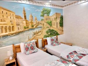 a room with two beds and a painting on the wall at SILVER Inn in Bukhara