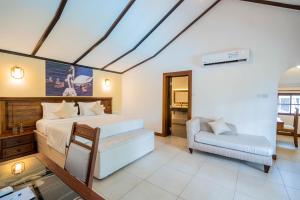 a bedroom with a bed and a couch and a chair at PrideInn Flamingo Beach Resort & Spa Mombasa in Mombasa