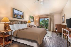 a hotel room with a bed and a living room at Yellowstone Valley Lodge, an Ascend Collection Hotel in Pray