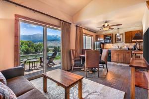 a living room with a couch and a table and a kitchen at Yellowstone Valley Lodge, an Ascend Collection Hotel in Pray