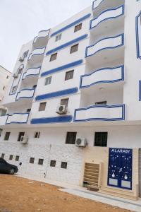 an apartment building with blue and white balconies at Alaraby 2 in Az Zaytīyah +1 photo