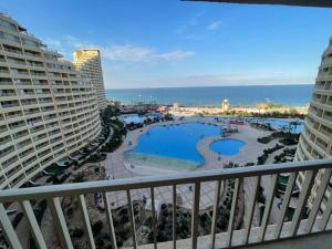 a view of a pool from the balcony of a resort at بورتو السخنه الاهرامات in Ain Sokhna +1 photo