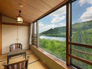 a room with a large window with a view of a river at Bousenkaku in Gosen