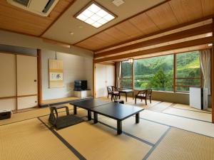 a room with a table and chairs and a window at Bousenkaku in Gosen
