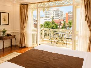 a bedroom with a balcony with a table and chairs at Dhavara Boutique Hotel in Vientiane +67 photos