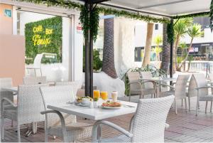a table with a plate of food on a patio at Welikehotel Fenix in El Arenal