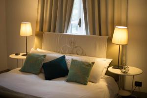 - une chambre avec un lit avec des oreillers et 2 lampes dans l'établissement Le Rondini, à Grions del Torre