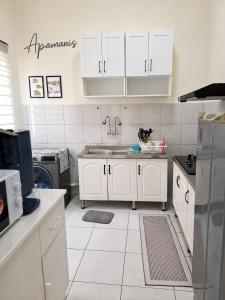 a kitchen with white cabinets and a sink at Homestay Apamanis, Alor Setar in Kepala Batas