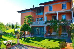 a large orange building with a lawn in front of it at Le Rondini in Grions del Torre