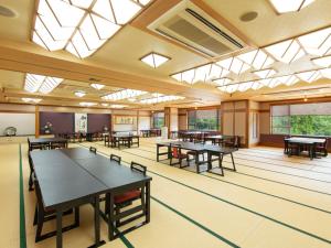 a large room with tables and chairs and windows at Bousenkaku in Gosen