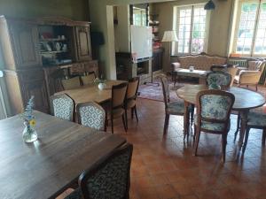 a dining room with wooden tables and chairs at Maison de caractère au calme en pleine campagne in Rollancourt