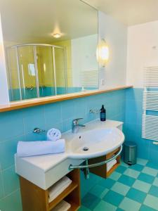 a bathroom with a sink and a mirror at Aparthotel Schindlhaus/Alpin in Söll +14 photos
