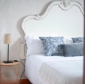 a white bed with blue pillows and a lamp at Villa balcón de azuaje in Moya