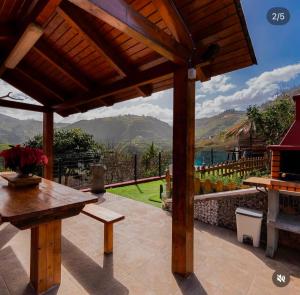 a patio with a wooden pergola and a table at Villa balcón de azuaje in Moya